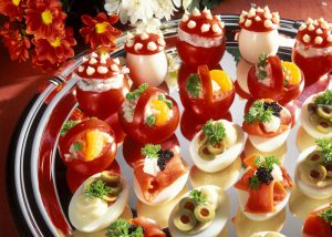 Stuffed eggs & tomatoes as snacks on serving platter
